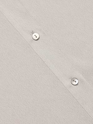 Close-up of the Capri Lace Sleeve Blouse in light beige, featuring a relaxed fit, diagonal stitching, and two white buttons. The soft textured fabric offers effortless style and comfort.