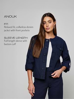Woman wearing a navy denim jacket with text describing the fit and sleeve length on a gray background