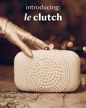 Pearl clutch held by a hand wearing a gold glove with 'introducing: le clutch' text.