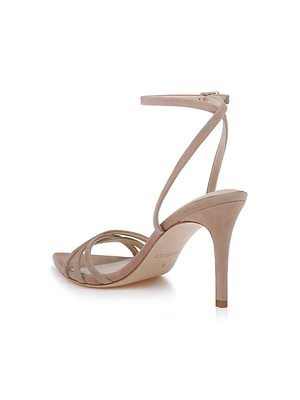 The Dua Suede Sandal is a tan suede stiletto with thin front straps and an ankle strap with a small buckle, shown against a white background.